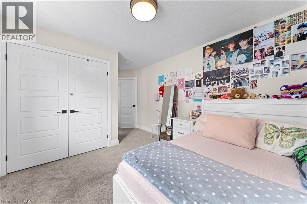 Spacious room featuring multi-panel double doors, neutral-toned carpeting, and a built-in flush mount ceiling light - 130 Pondcliffe Drive, Kitchener, ON - Indoor Photo Showing Bedroom
