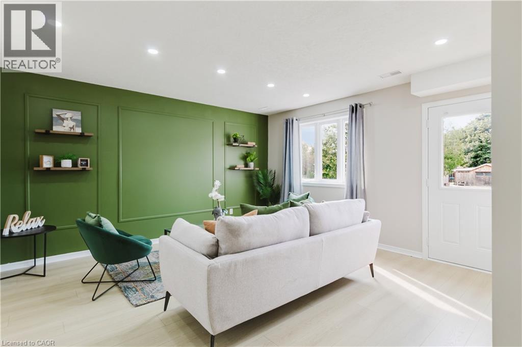 Recessed lighting illuminating a feature wall with decorative molding, light wood-finish flooring, and multiple windows - 67 Kinzie Avenue, Kitchener, ON - Indoor Photo Showing Living Room