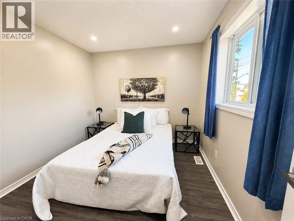 Recessed ceiling lighting, wood-finish flooring, and a single window with blue drapes - 67 Kinzie Avenue, Kitchener, ON - Indoor Photo Showing Bedroom
