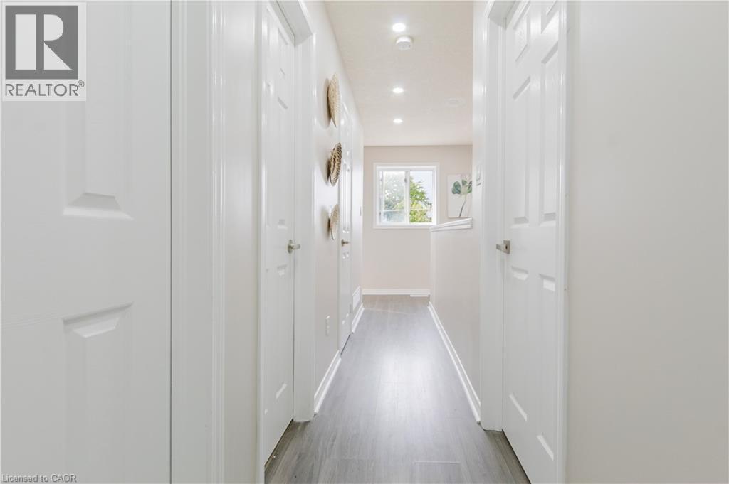 Hallway featuring recessed lighting, wood-finish flooring, white paneled doors, and a window - 67 Kinzie Avenue, Kitchener, ON - Indoor Photo Showing Other Room
