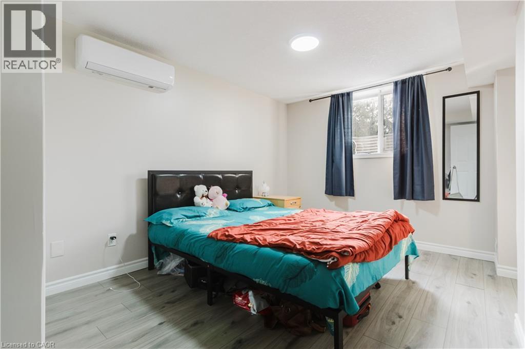 Durable wood-finish flooring, white painted walls, and a window for natural light - 67 Kinzie Avenue, Kitchener, ON - Indoor Photo Showing Bedroom