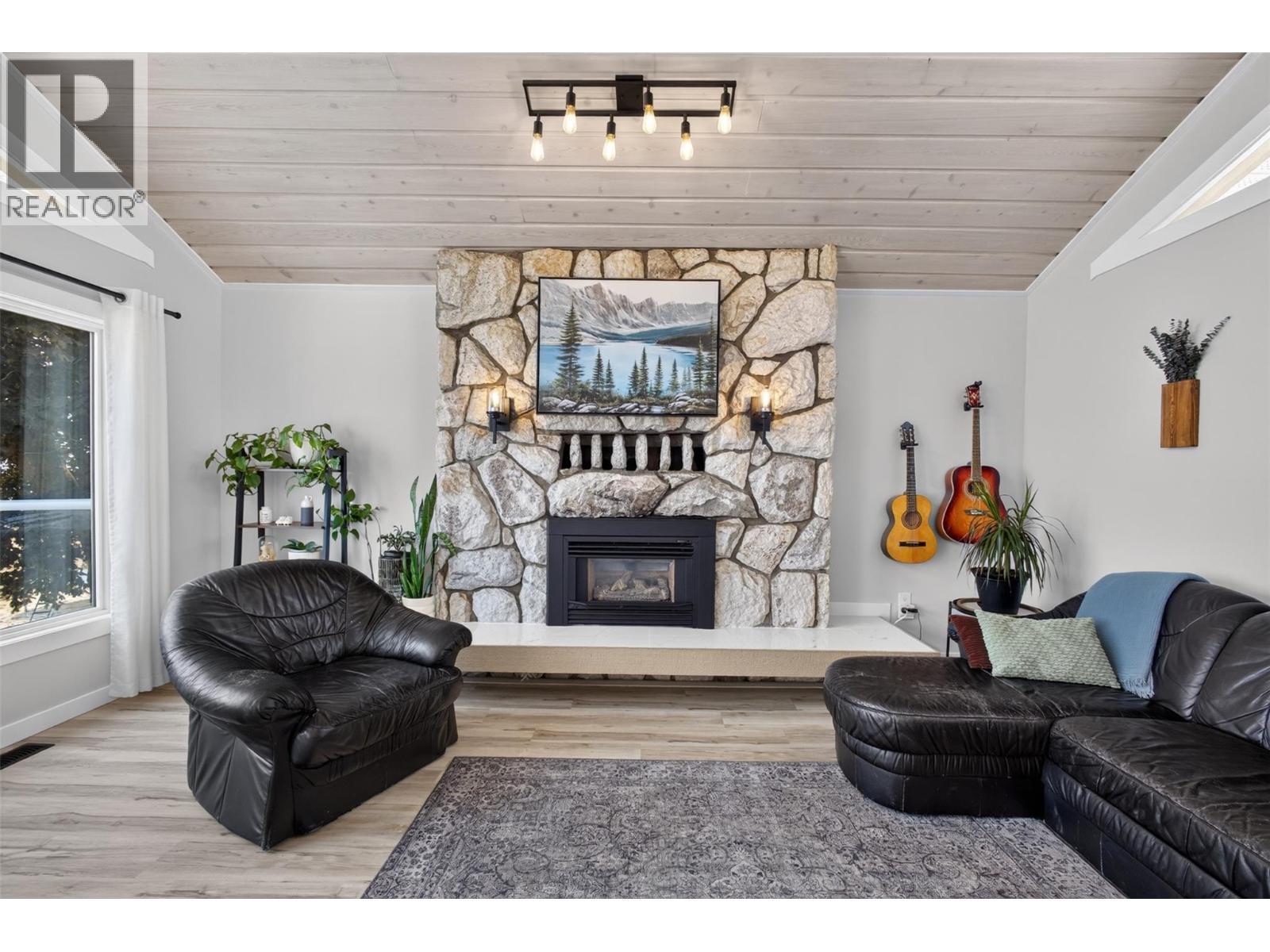 Stone fireplace anchors the space - 3491 Fenton Road, West Kelowna, BC - Indoor Photo Showing Dining Room