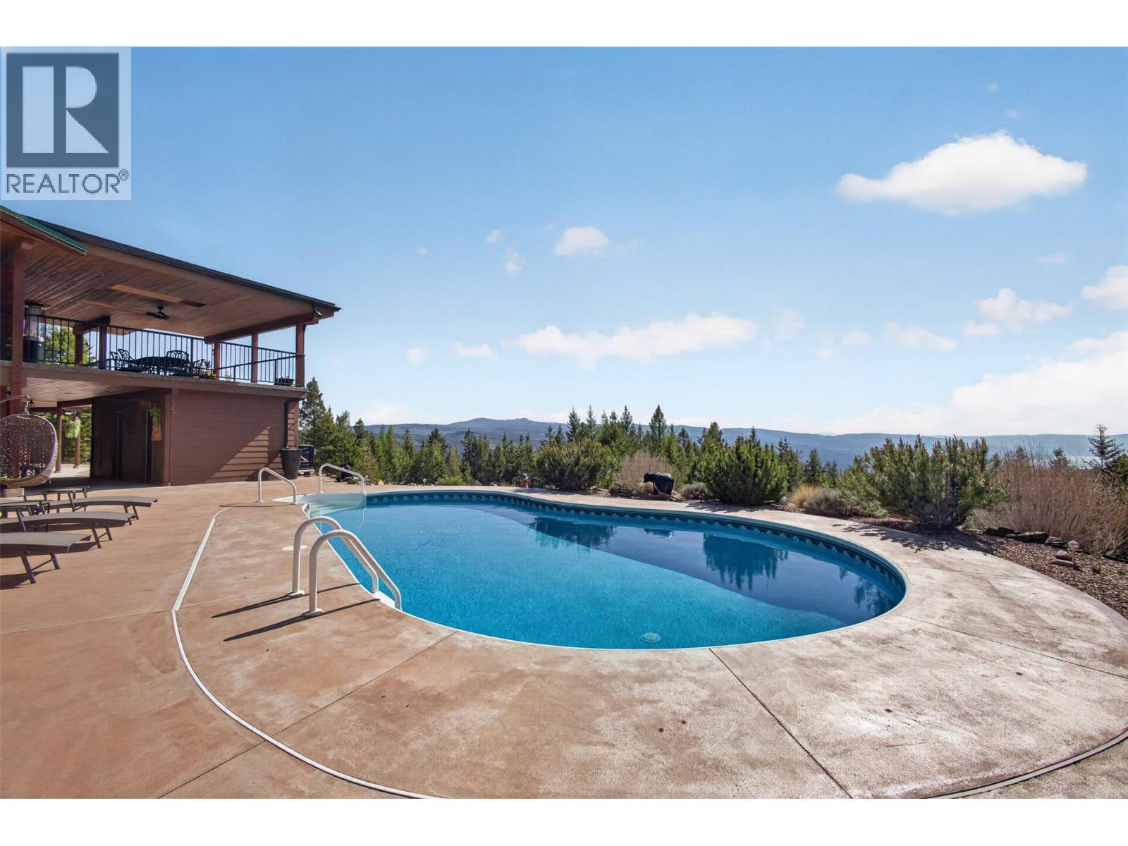 Kidney shaped pool overlooking the gorgeous Okanagan - 7319 Trapper Court, Kelowna, BC - Outdoor With In Ground Pool