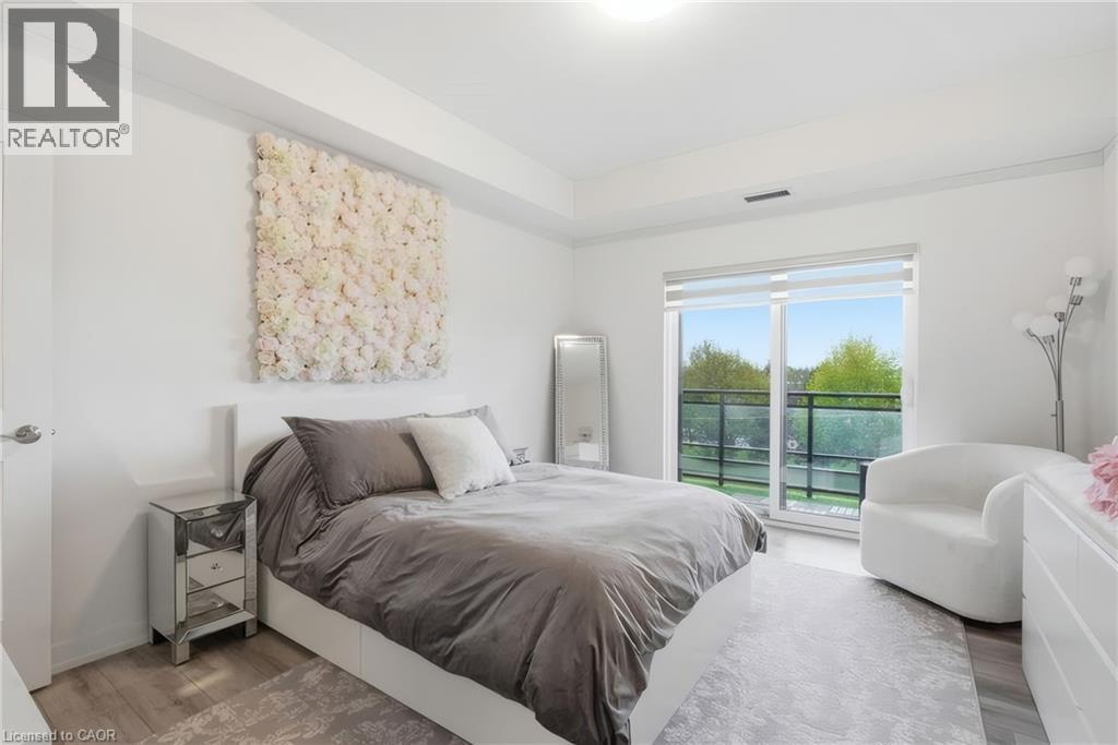 Slider door to outdoor balcony, wood-finish flooring, recessed lighting, and high ceilings - 251 Northfield Drive E Unit# 312, Waterloo, ON