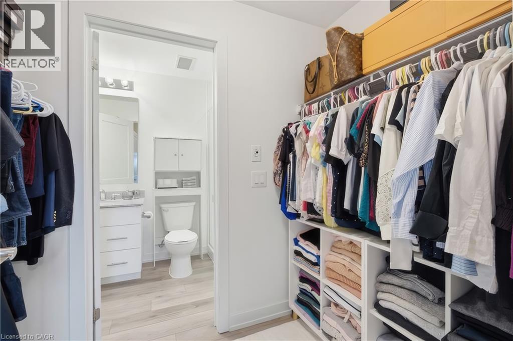 Custom closet organization system with hanging rods and integrated shelving - 251 Northfield Drive E Unit# 312, Waterloo, ON