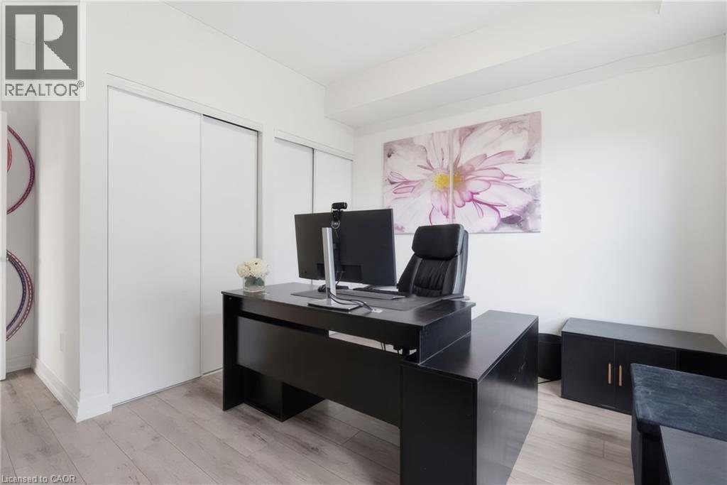 Wood-finish flooring with white walls and built-in closet doors - 251 Northfield Drive E Unit# 312, Waterloo, ON