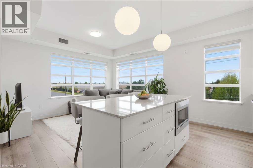 Open-concept living space with light wood-finish flooring - 251 Northfield Drive E Unit# 312, Waterloo, ON