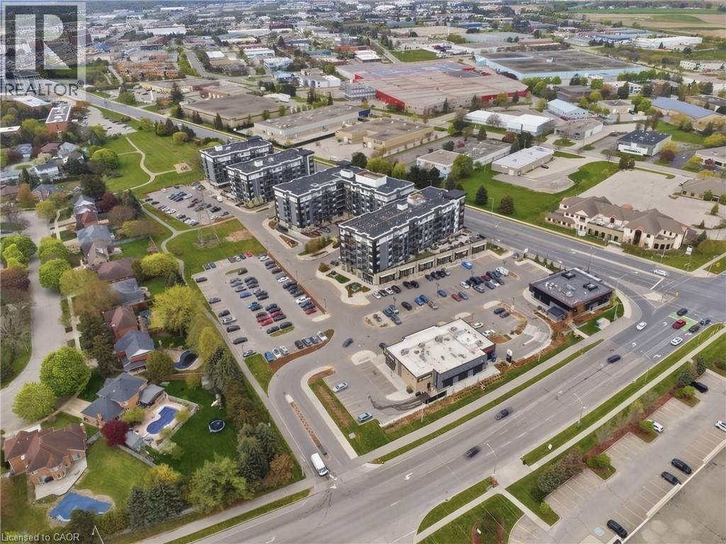 Contemporary residential buildings with multiple stories, ample on-site parking, and surrounding commercial structures - 251 Northfield Drive E Unit# 312, Waterloo, ON