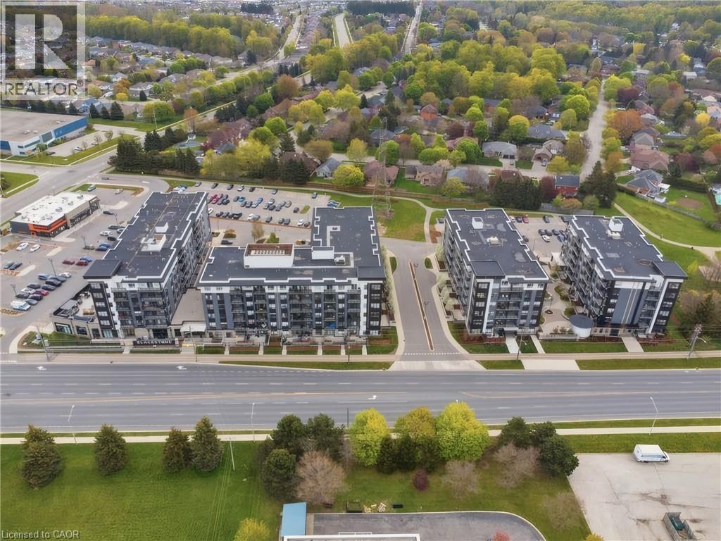 Modern multi-story apartment buildings with balconies, adjacent to a commercial plaza and surface parking - 251 Northfield Drive E Unit# 312, Waterloo, ON