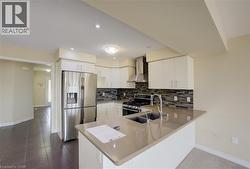 Kitchen featuring stainless steel appliances, modern cabinetry, a tile backsplash, an island with an undermount sink, and recessed lighting - 