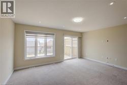 Bright interior with neutral-toned walls and carpet flooring - 