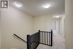 Hallway with plush carpeting, neutral wall color, and flush-mount ceiling fixtures - 