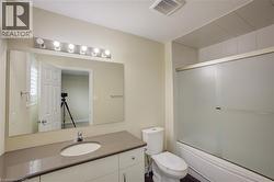 Vanity with an integrated sink, polished chrome faucet, and expansive mirror with overhead lighting - 
