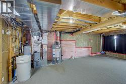 Unfinished basement with exposed wood joists, ceiling-mounted ductwork, and insulation - 