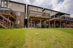 Rear exterior featuring multiple decks, wood railings, and walk-out access - 