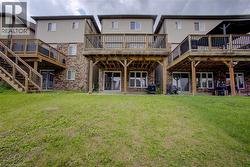 Expansive rear yard with multi-level wooden decks and brick and siding exterior - 