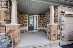 Brick facade with white columns and a covered concrete porch - 
