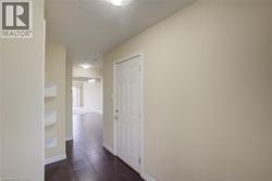 Recessed ceiling lighting, paneled interior door, dark-toned floor tiles, light-toned walls, built-in shelving - 