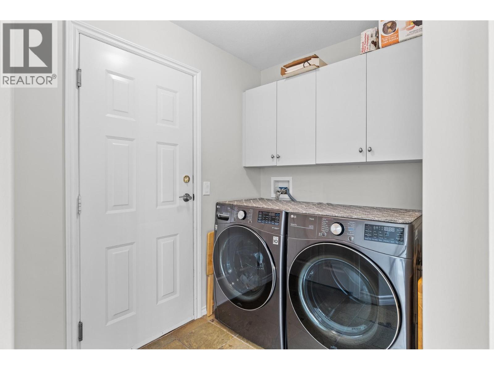 Main floor laundry and entrance to garage. - 4400 Gallaghers Drive E Unit# 2, Kelowna, BC - Indoor Photo Showing Laundry Room