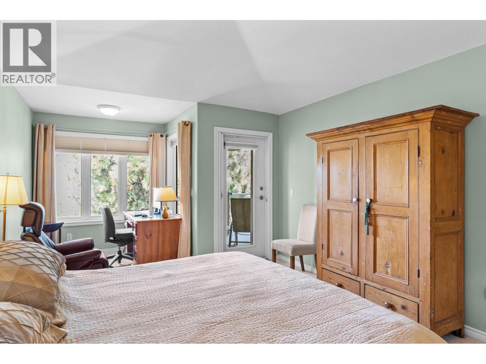 Primary bedroom with access to view deck. - 4400 Gallaghers Drive E Unit# 2, Kelowna, BC - Indoor Photo Showing Bedroom
