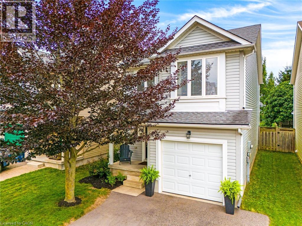 Siding exterior with a peaked roofline, front-facing garage, and mature front yard tree - 711 Angler Way, Waterloo, ON - Outdoor