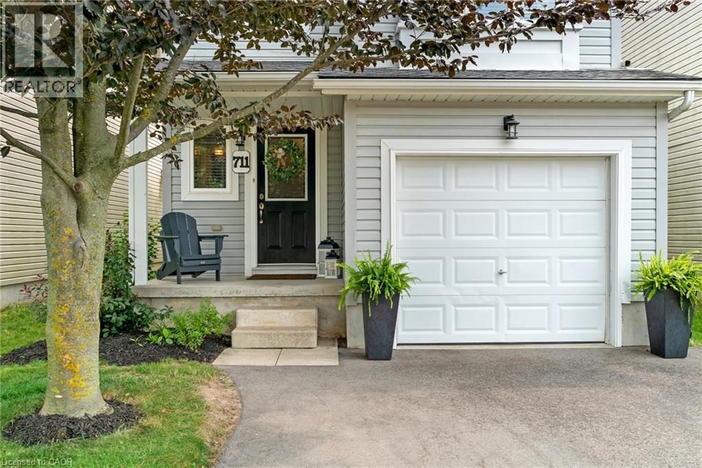 Light grey siding exterior with a white paneled garage door - 711 Angler Way, Waterloo, ON - Outdoor