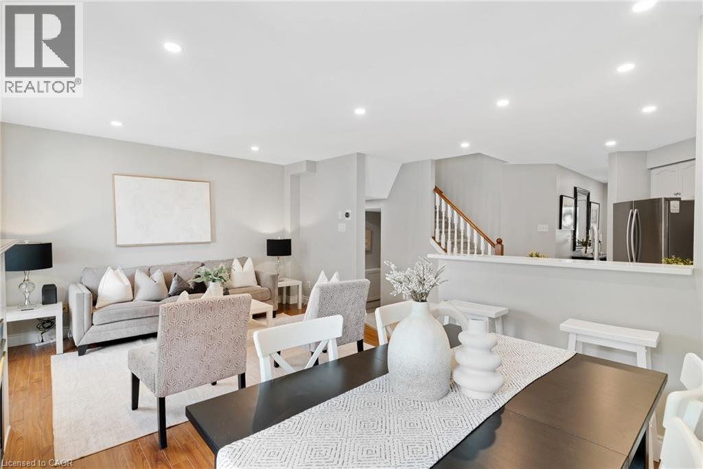 Open-concept living space featuring wood-finish flooring, recessed lighting, a kitchen pass-through, and stainless steel appliances - 711 Angler Way, Waterloo, ON - Indoor