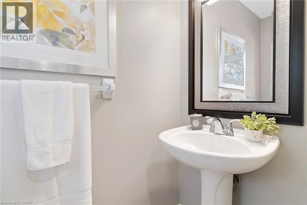 Pedestal sink with chrome-finish faucet, framed mirror, and light-toned wall paint - 711 Angler Way, Waterloo, ON - Indoor Photo Showing Bathroom