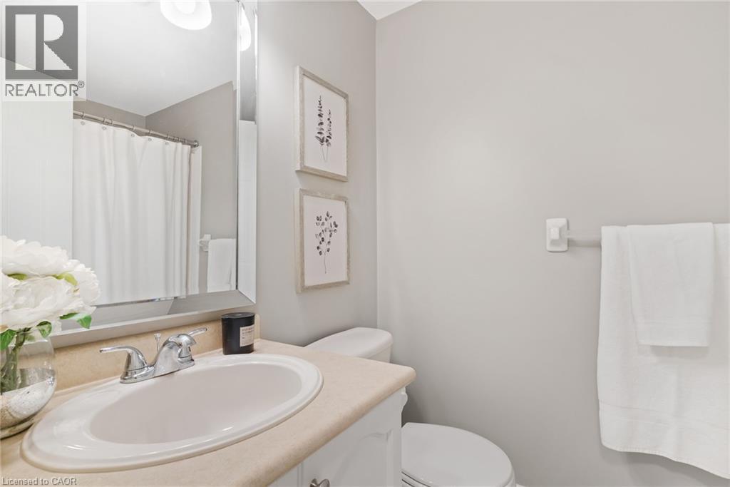 Vanity with integrated sink and chrome faucet, large wall mirror, and neutral wall tones - 711 Angler Way, Waterloo, ON - Indoor Photo Showing Bathroom