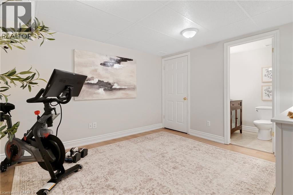 Wood-finish flooring, recessed lighting, and a white interior door - 711 Angler Way, Waterloo, ON - Indoor Photo Showing Gym Room
