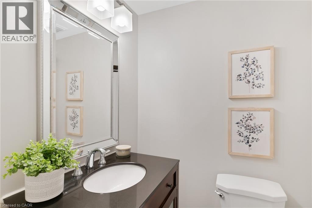 Vanity with an integrated oval sink, chrome faucet, and dark countertop - 711 Angler Way, Waterloo, ON - Indoor Photo Showing Bathroom