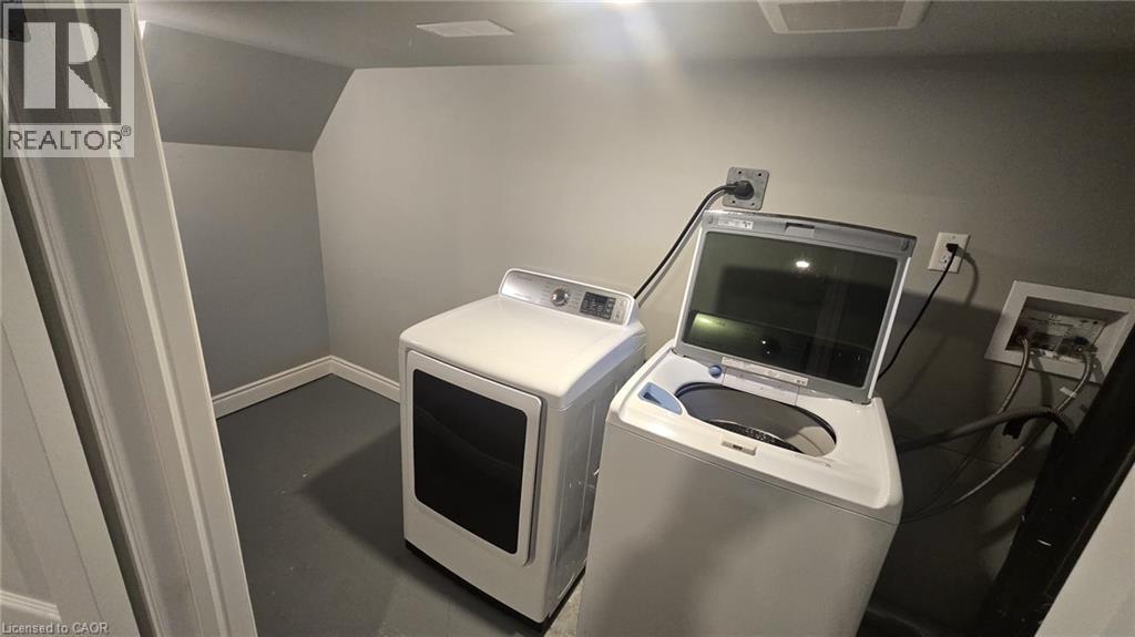 Dedicated laundry area with sloped ceiling and light gray walls - 216 Brunswick Crescent, London, ON