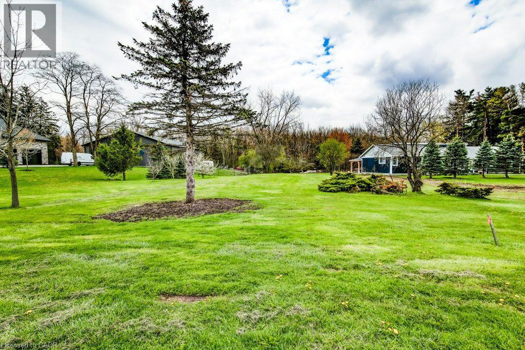 Expansive green space featuring scattered mature trees and landscaped shrubbery - 121 Dodge Drive, Kitchener, ON