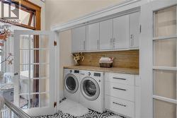 Laundry on the same level as the primary bedroom with granite counter and ample storage tucked behind French doors. - 
