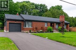 Brick exterior with dark shingle roof and integrated garage - 