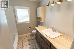 Bathroom featuring a vanity with integrated sink, a light-toned countertop, and dark cabinetry - 