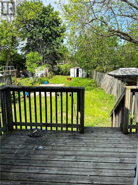 Rear wooden deck with a slatted railing and steps - 218 East 8Th Street, Hamilton, ON - Outdoor