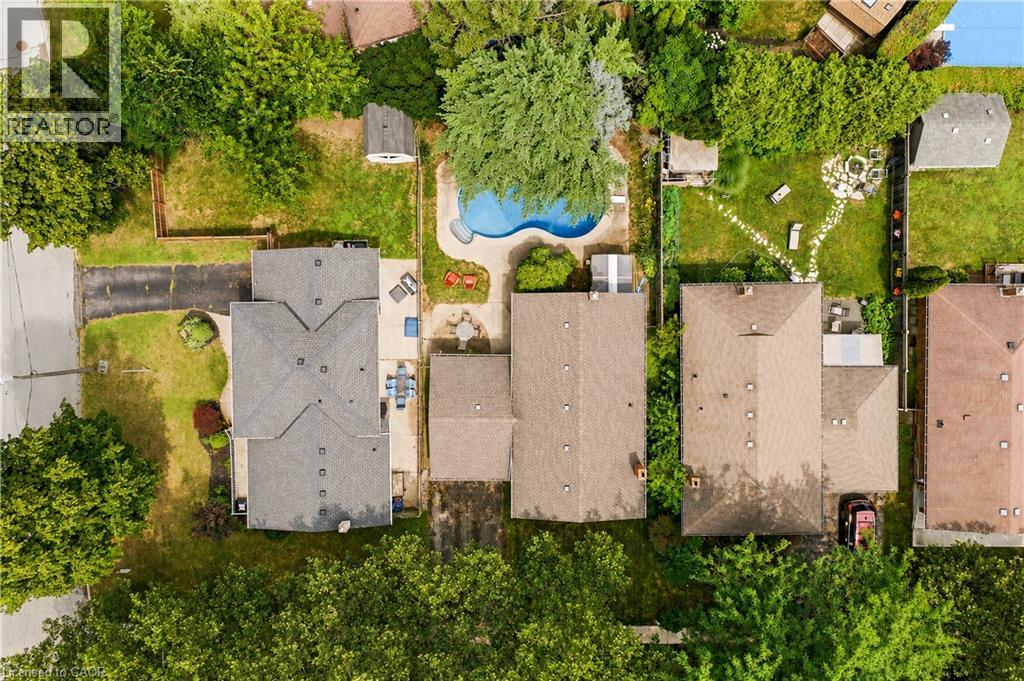 Residential property featuring a grey shingled roof, paved driveway, and established front landscaping - 11 Kimbermount Drive, St. Catharines, ON - Outdoor With View