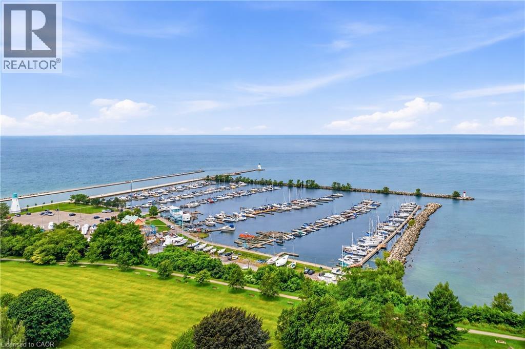 Expansive waterfront setting featuring a marina with numerous boat slips, a tranquil body of water, and a tree-lined shoreline - 11 Kimbermount Drive, St. Catharines, ON - Outdoor With Body Of Water With View