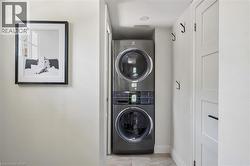 Built-in stacked washer and dryer, recessed overhead lighting, and paneled storage cabinetry -