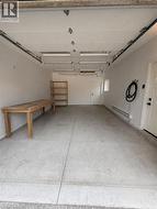Concrete flooring, multiple overhead fluorescent lights, a side entry door, and a single window -