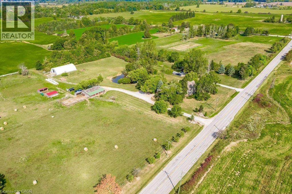 Expansive green acreage featuring multiple outbuildings, a private pond, and direct road frontage - 2108 Westbrook Road, Binbrook, ON