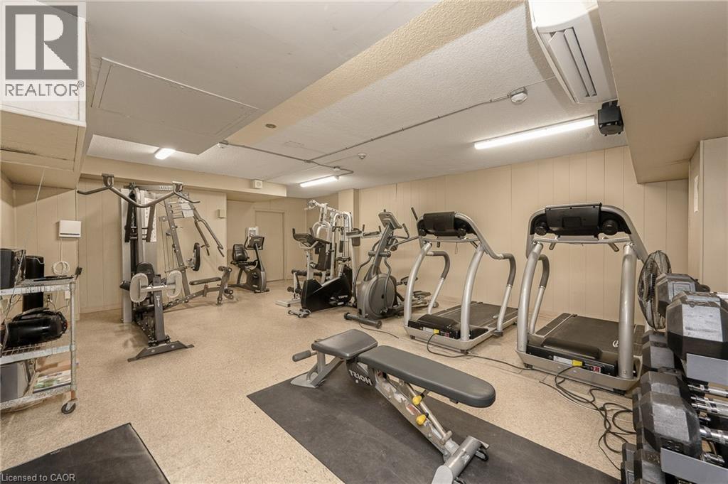State-of-the-art fitness facility featuring multiple cardio machines, strength training equipment, and functional exercise stations - 975 Warwick Court Unit# 708, Burlington, ON - Indoor Photo Showing Gym Room