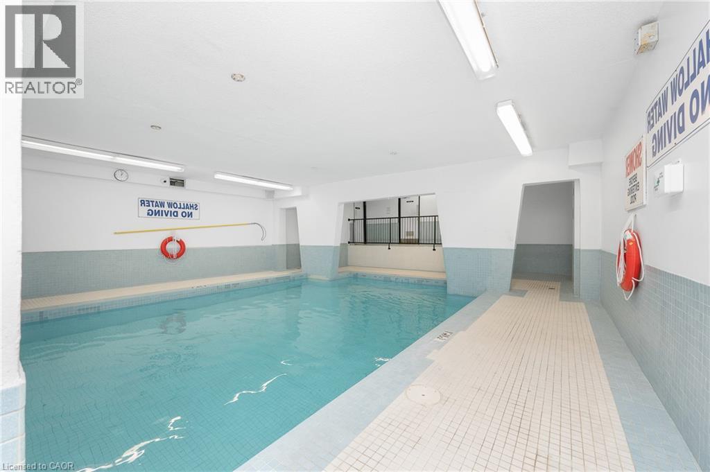 Indoor swimming pool with light blue and white tile accents - 975 Warwick Court Unit# 708, Burlington, ON - Indoor Photo Showing Other Room
