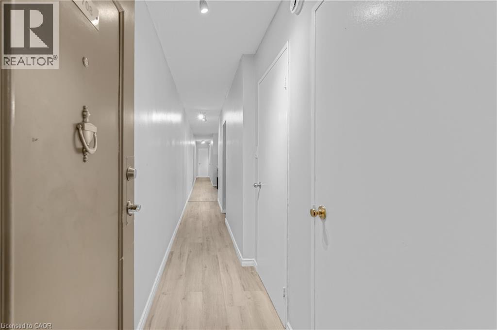Entry corridor featuring wood-finish flooring and track lighting - 975 Warwick Court Unit# 708, Burlington, ON - Indoor