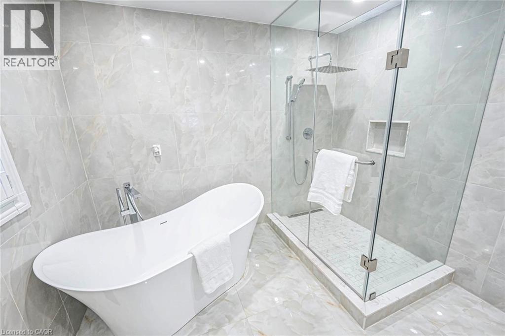 Freestanding soaking tub and glass-enclosed shower with rain shower head - 247 Sand Road, Holland Landing, ON - Indoor Photo Showing Bathroom