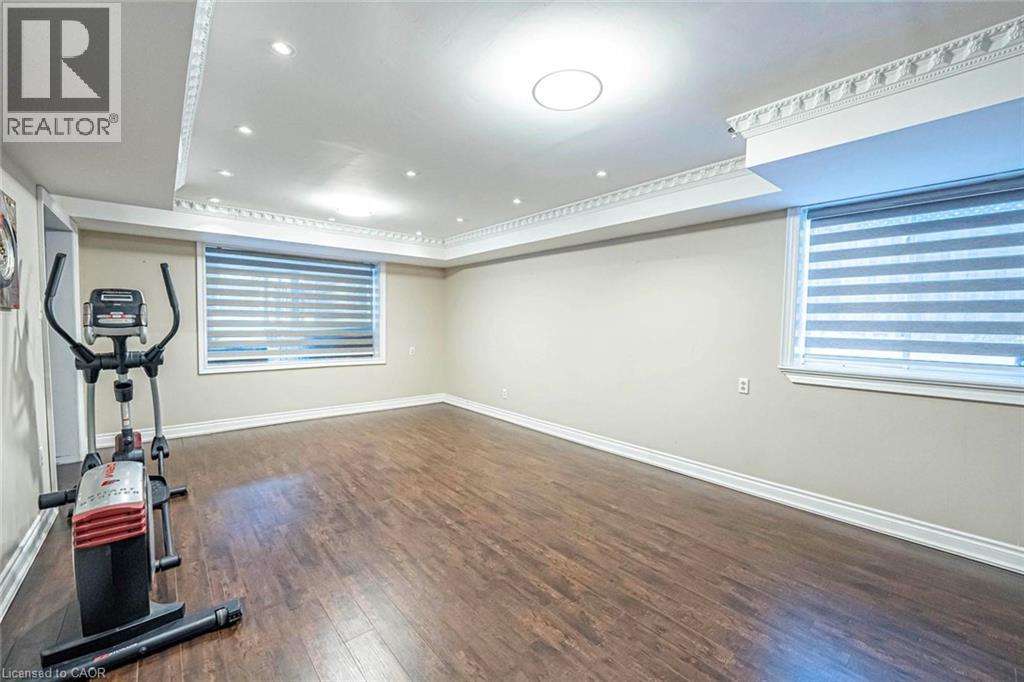 Spacious interior room featuring wood-finish flooring, neutral wall tones, and multiple windows with horizontal blinds - 247 Sand Road, Holland Landing, ON - Indoor Photo Showing Other Room