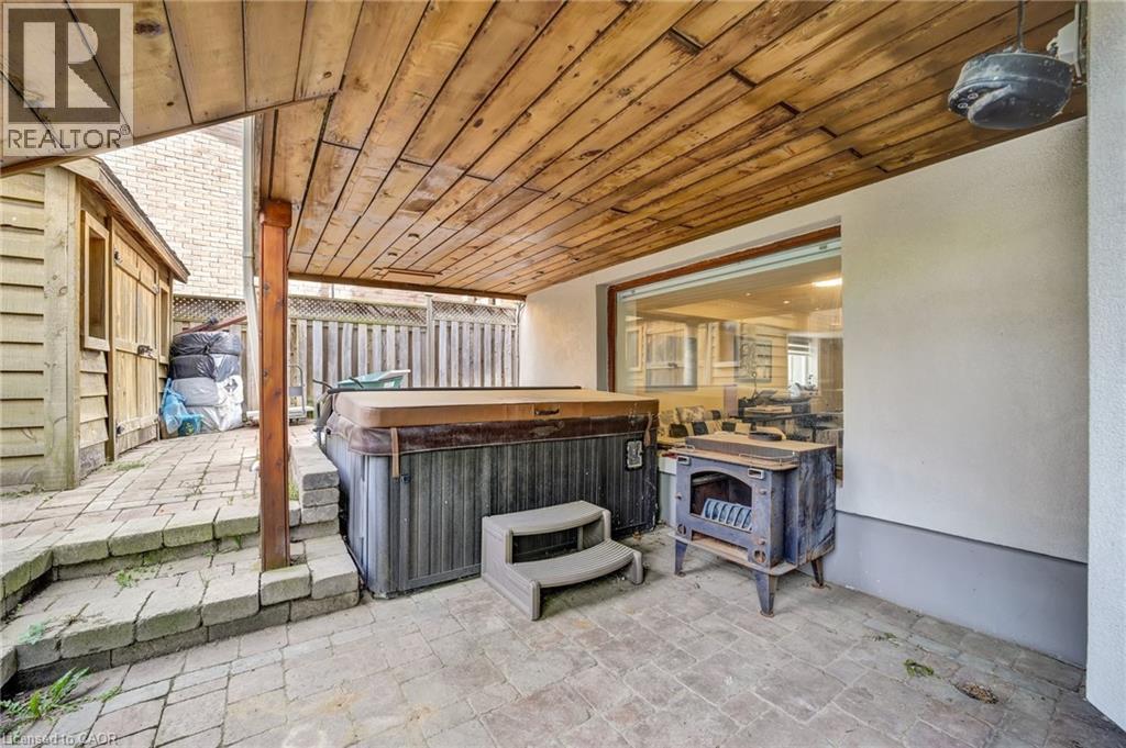 Covered patio featuring a wood-finish ceiling, brick paver flooring, and a built-in hot tub - 247 Sand Road, Holland Landing, ON - Outdoor With Exterior