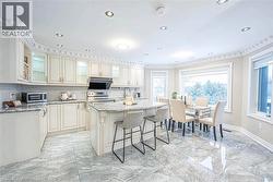 Eat-in kitchen featuring white cabinetry, granite countertops, stainless steel appliances, and tile flooring -