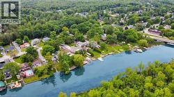 Waterfront properties with private docks, lush green surroundings, and mature trees lining the riverbank -